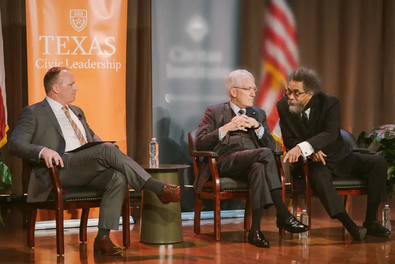Cornel West and Robert P. George Debating on stage with Dean Justin Dyer hosting.